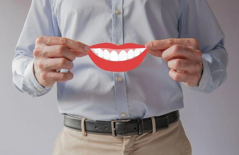 Osoba trzymająca uśmiechnięte usta z papieru